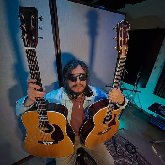 Jerzel en el estudio con dos guitarras acústicas